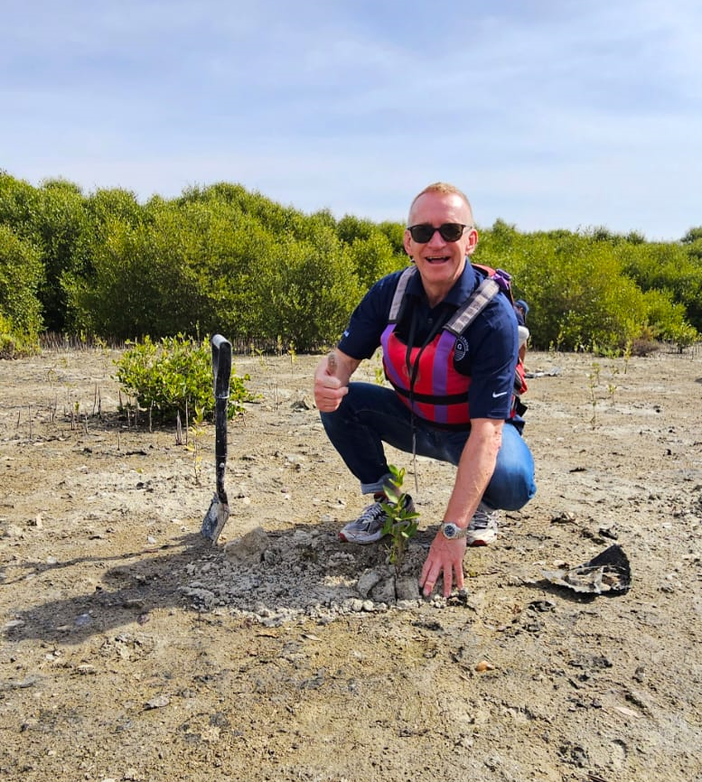 Unique Group COO planting mangrove sapling as part of sustainability efforts