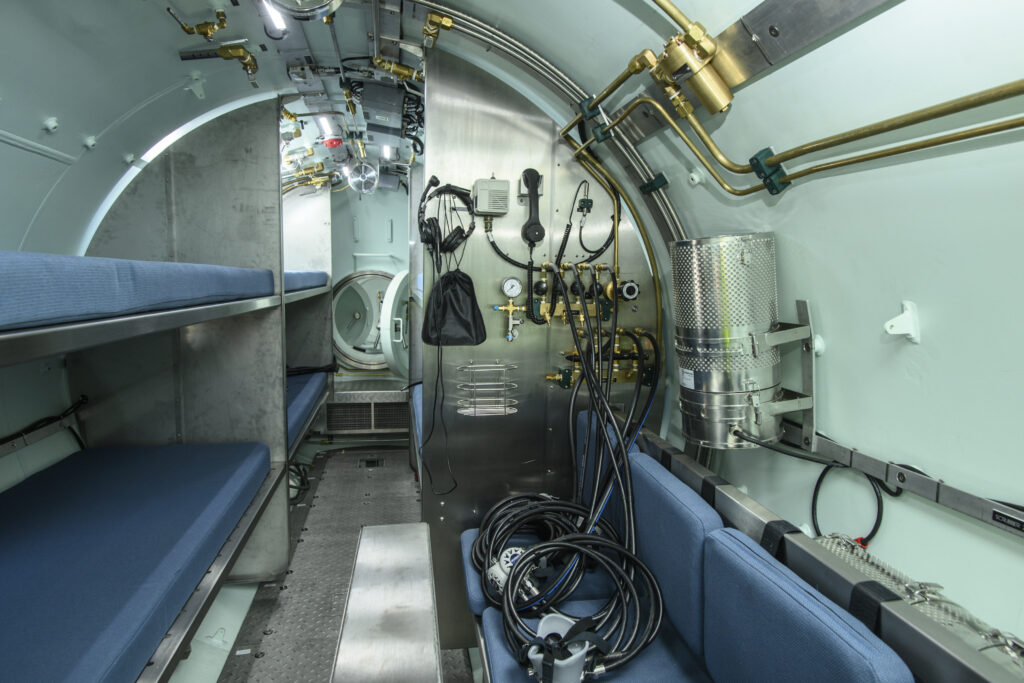 Diving Medical Advisory Council (DMAC) compliant facility with berths, seating, a basin, and tiltable bunks.