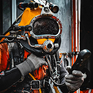 Commercial diver wearing helmet and life support system for offshore diving operations