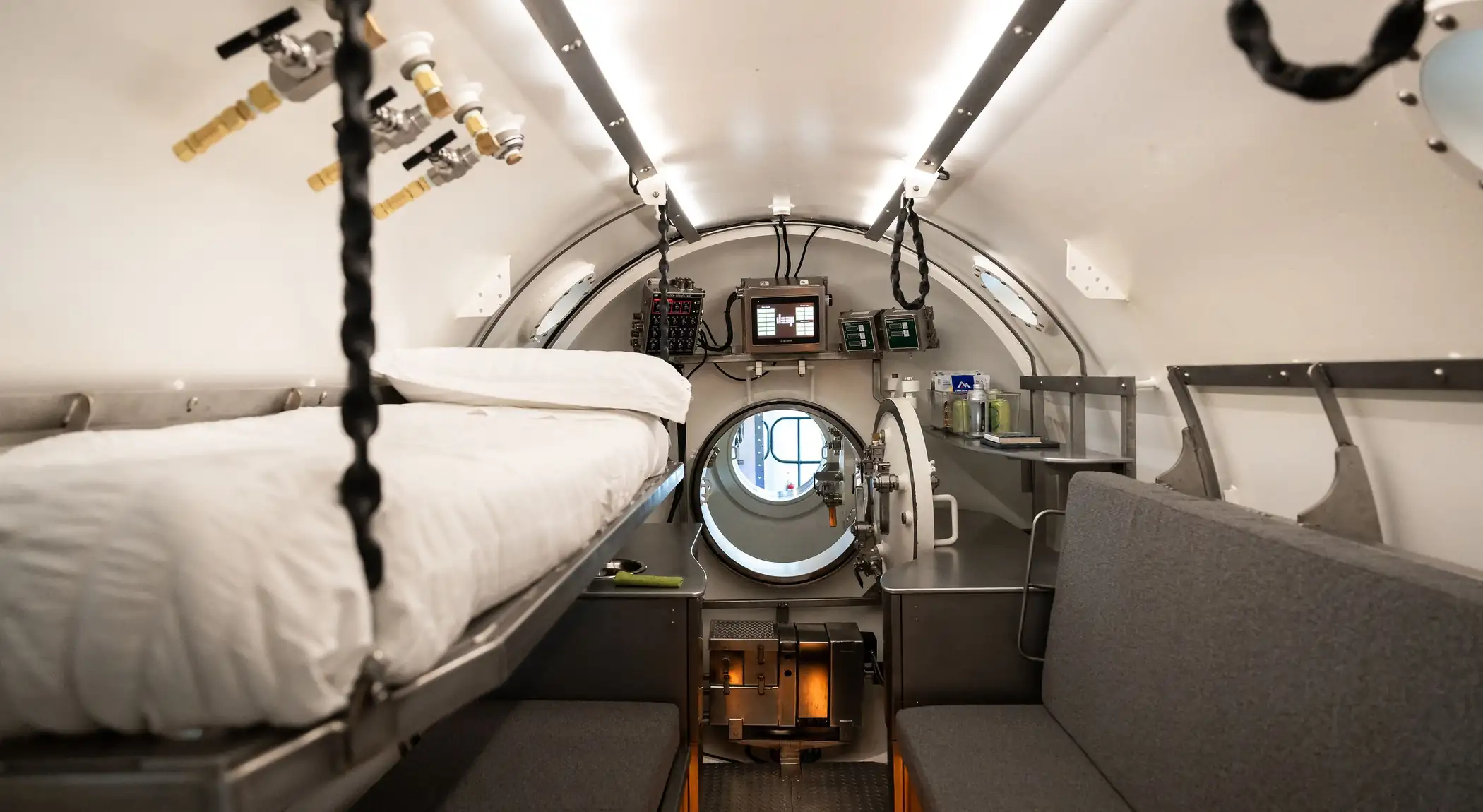 Interior of Vanguard's living chamber showing bespoke furniture, sleeping berth and control interface