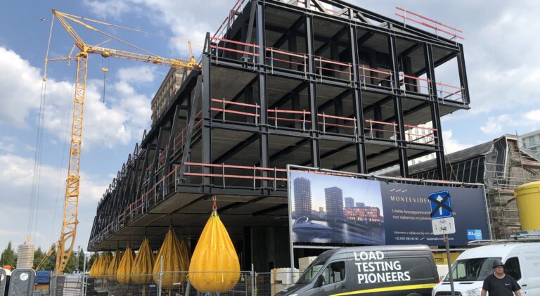 Unique Group Water Weights load testing bags suspended beneath a residential building under construction in Belgium