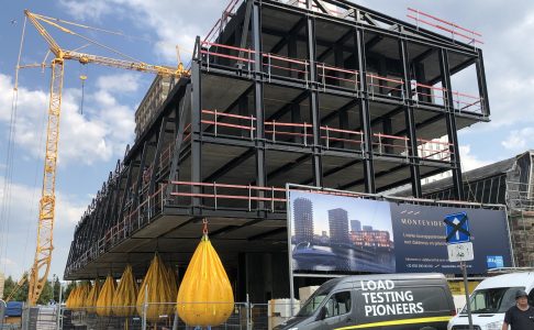 Unique Group Water Weights load testing bags suspended beneath a residential building under construction in Belgium